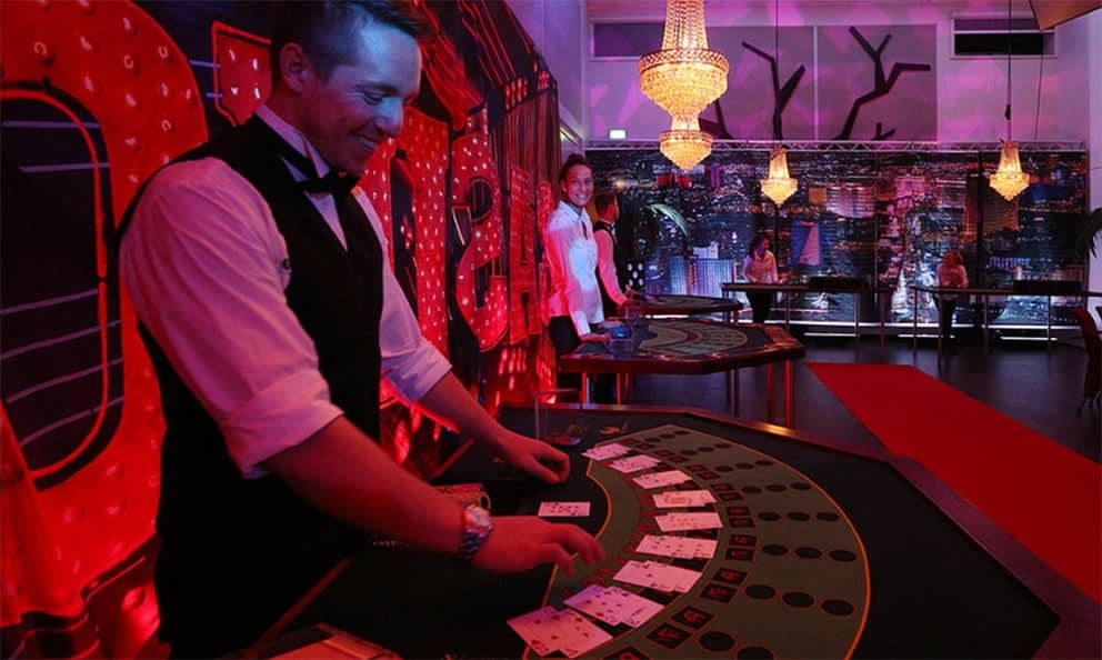 Dealer i aktion ved blackjack-bordet med festlig kulisse