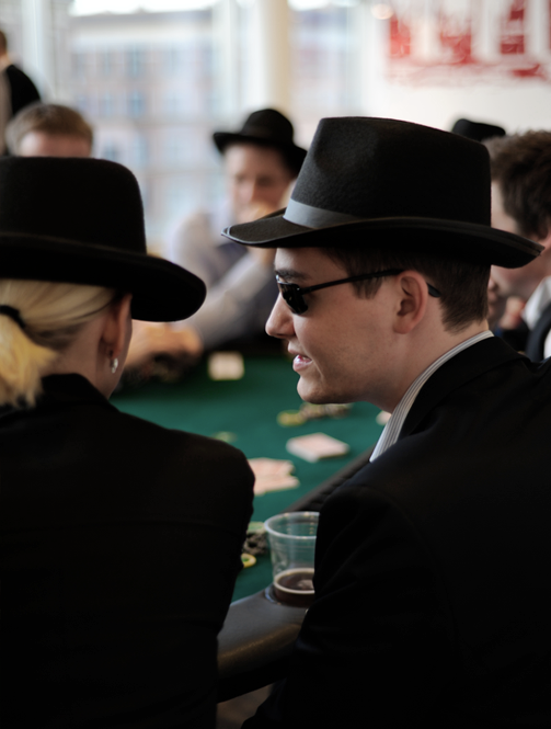 Gæster med hatte spiller poker til firmafest